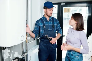 Plumber explains plumbing equipm ent to a woman