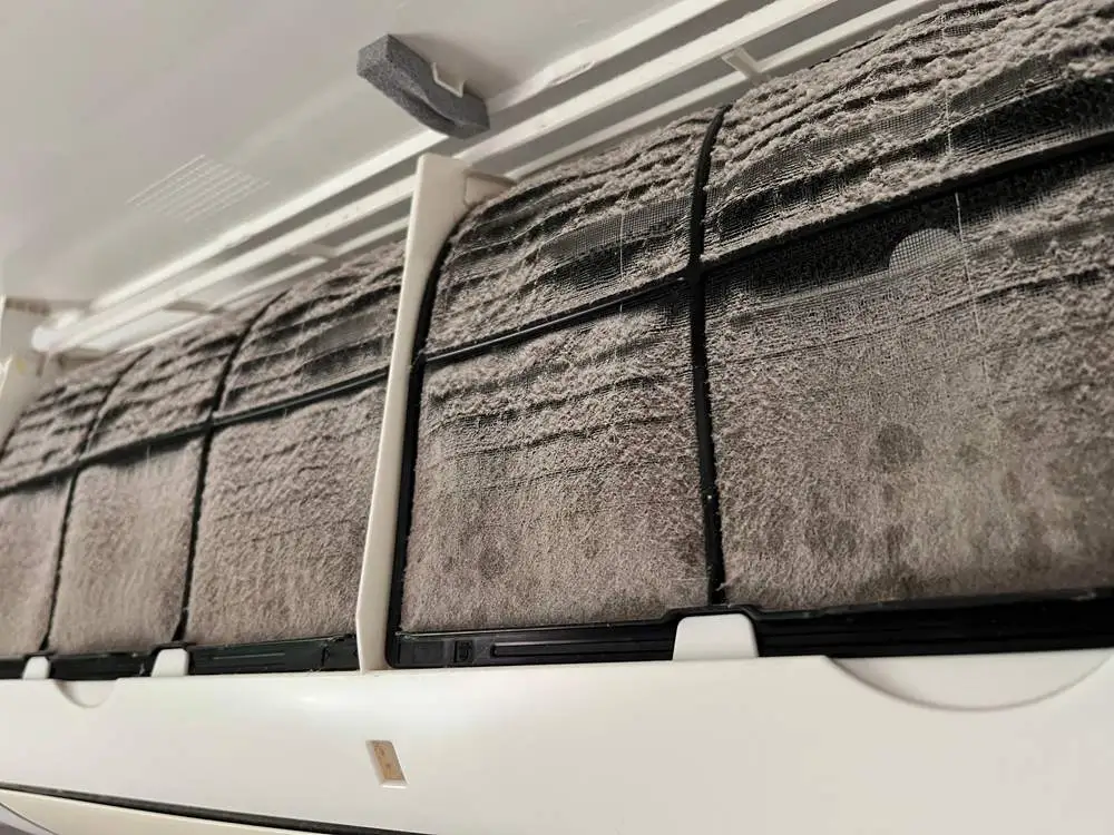 Dirty air filter about to be cleaned or replaced by hvac technician