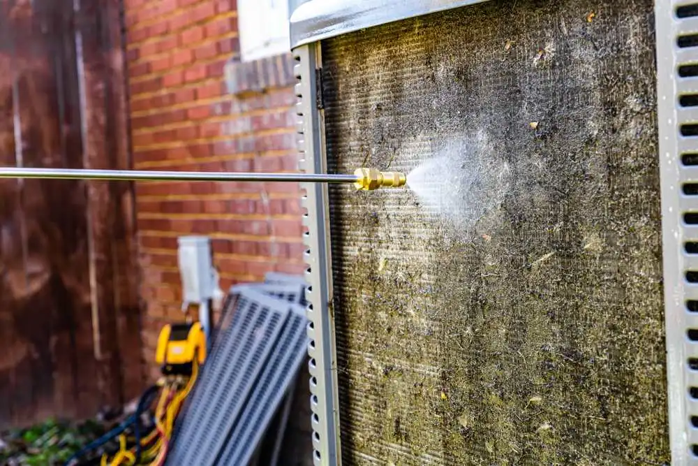 hvac-technician-cleaning-air-conditioner-rising-condenser coil (1)
